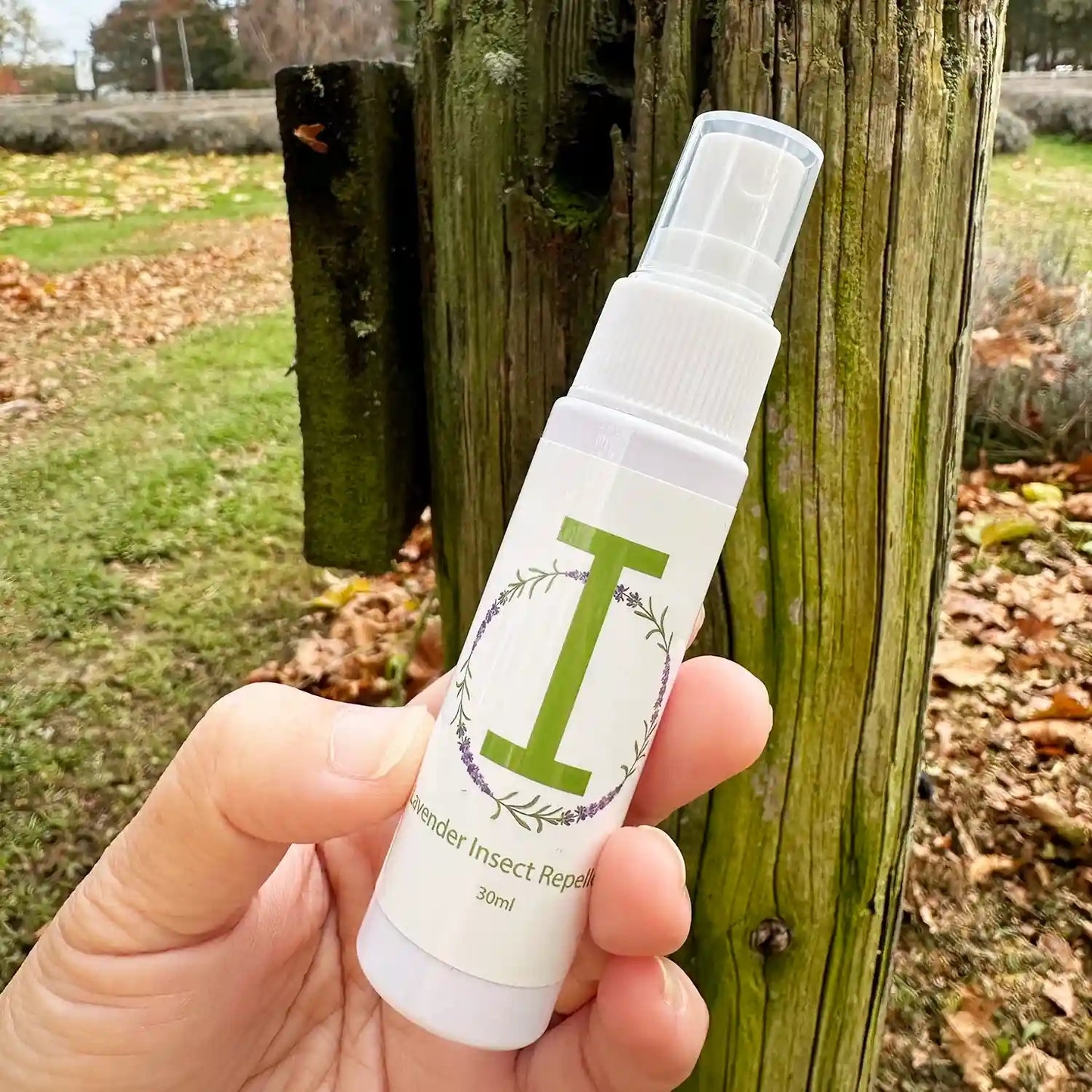 30ml travel-sized insect repellent mist with a backdrop of a New Zealand lavender farm paddock.