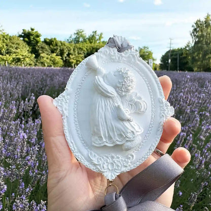 Close-up of an angel-shaped scented stone diffuser set against blooming lavender flowers at Lavender Backyard Garden, New Zealand.