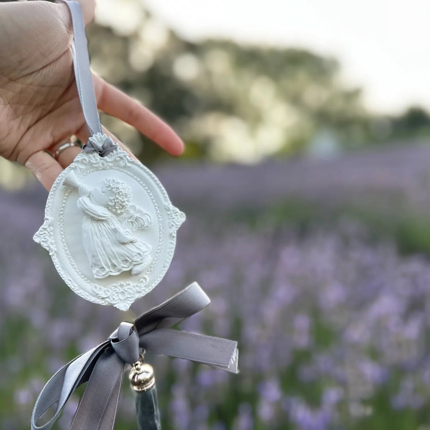 Angel-shaped scented stone diffuser set against a vibrant purple lavender field, evoking a sense of calm and serenity.