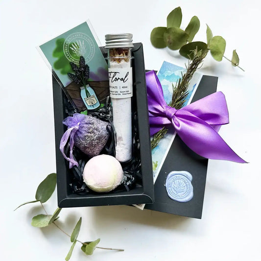 Bath Bliss Simple Gift Set featuring a lavender sachet, lavender-scented bath bomb, bath salt infused with lavender essential oil, and a lavender fridge magnet, all wrapped in a charming package.