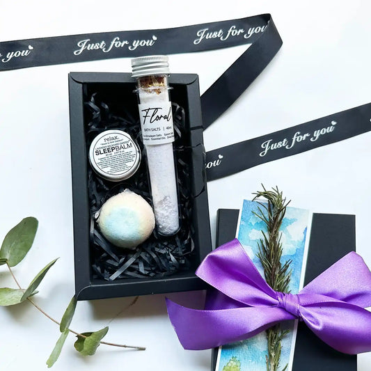 A beautifully arranged Beautiful Floral Spa Gift Set, featuring sleep aid balm, bath bomb, and bath salts, all scented with essential oils from a New Zealand lavender farm, elegantly packaged and ready for a relaxing experience.