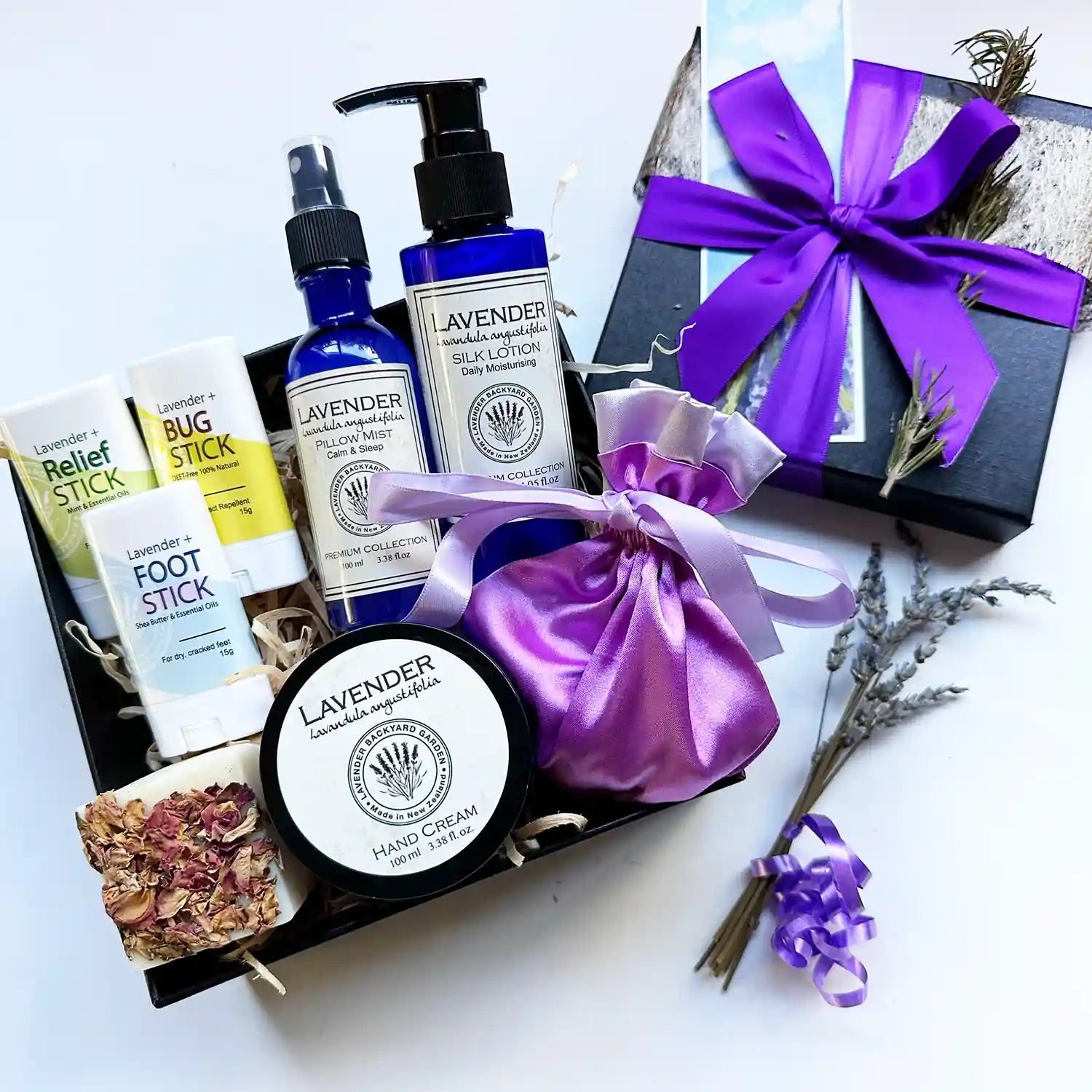 Lavender Wellbeing Body Care Gift Box featuring Lavender Pillow Mist, Moisturizing Lavender Body Lotion, Lavender Hand Cream, Lavender Foot Stick, Lavender Insect Repellent Balm, Lavender Soothe & Heal Balm, Luxury Satin Lavender Sachet Bag, Handcrafted Lavender Essential Oil Soap, Mini Lavender Dried Flowers, and Lavender Field Bookmark for a complete self-care experience.