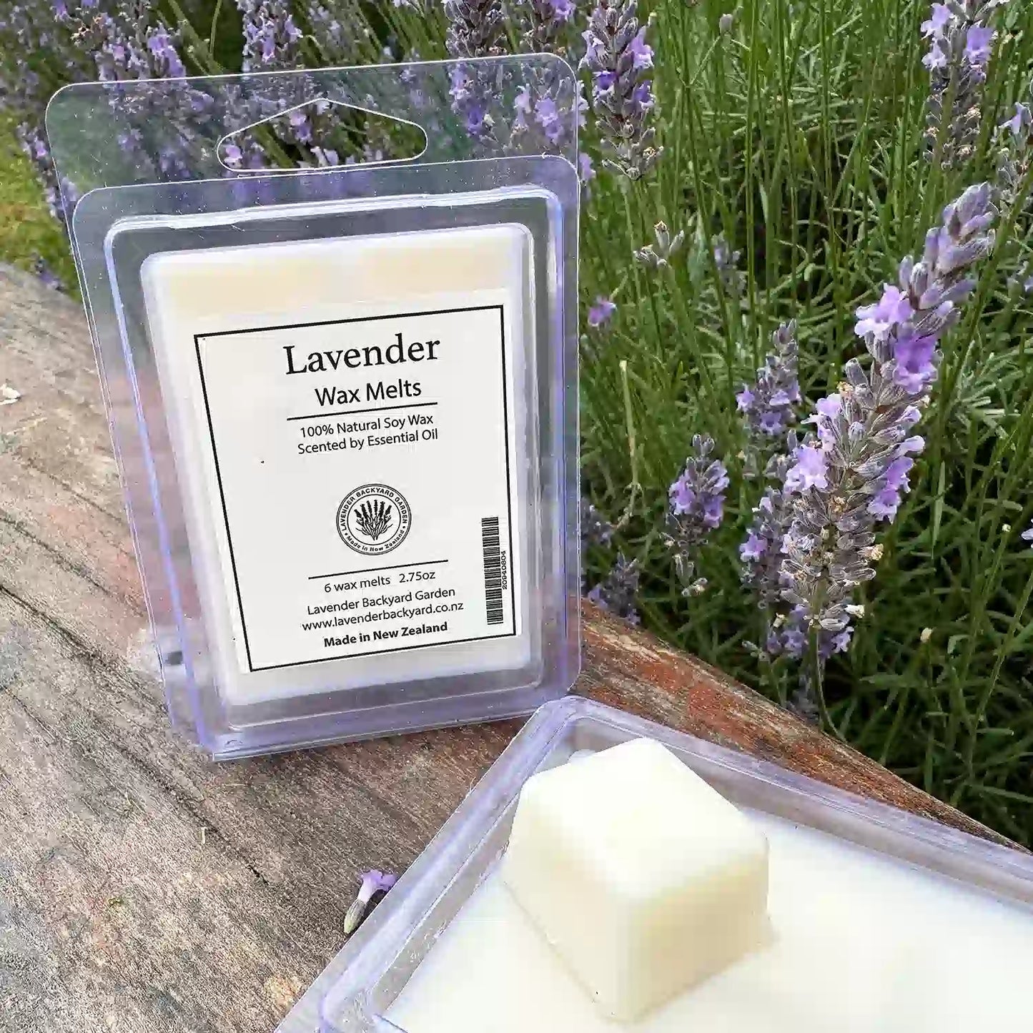 Close-up view of a lavender-scented cube wax melt, with lavender flowers in the background.