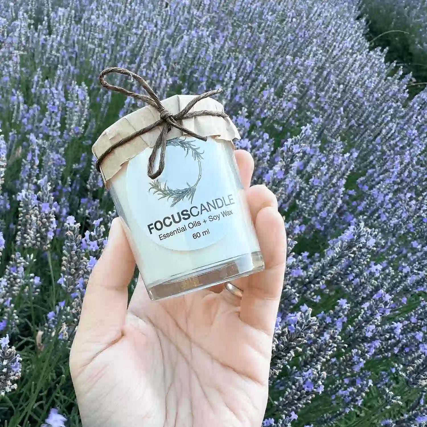 Close-up view of Focus Lavender Rosemary Soy Candles, displayed with a soft glow, against a backdrop of lavender blooms at Lavender Backyard Garden, NZ.