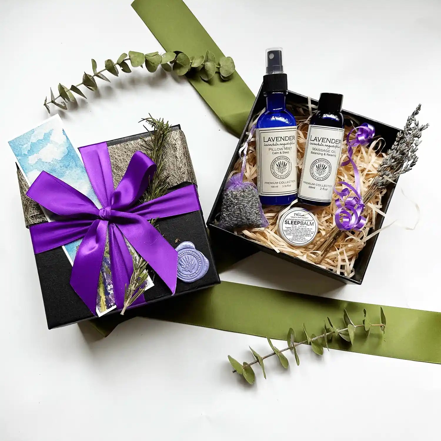 Fall Asleep Faster Lavender Gift Box containing lavender sleep spray, massage oil, and sleep balm, all scented by essential oils, wrapped with a purple ribbon, black gift box, and a lavender field bookmark.