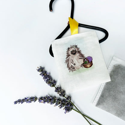 Farm animal hedgehog linen sachet for drawers with a background of fresh lavender flower stems and inner plain sachets pack.