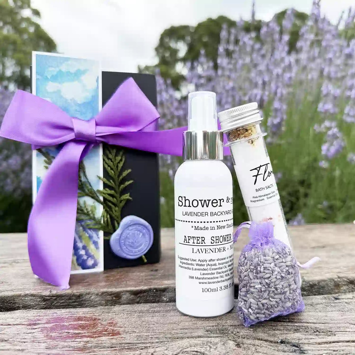 Impressive thank you gift set displayed against the background of a lavender field, featuring products such as a dried lavender sachet, lavender and mint after-shower mist, floral bath salts tube, and a lavender field bookmark.