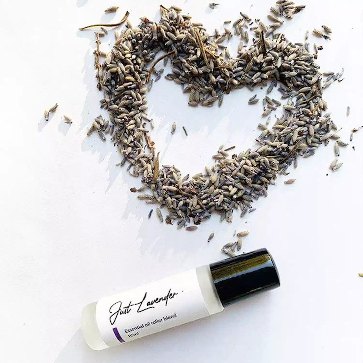 Just lavender roll on perfume with background of heart dried lavender buds shapes.