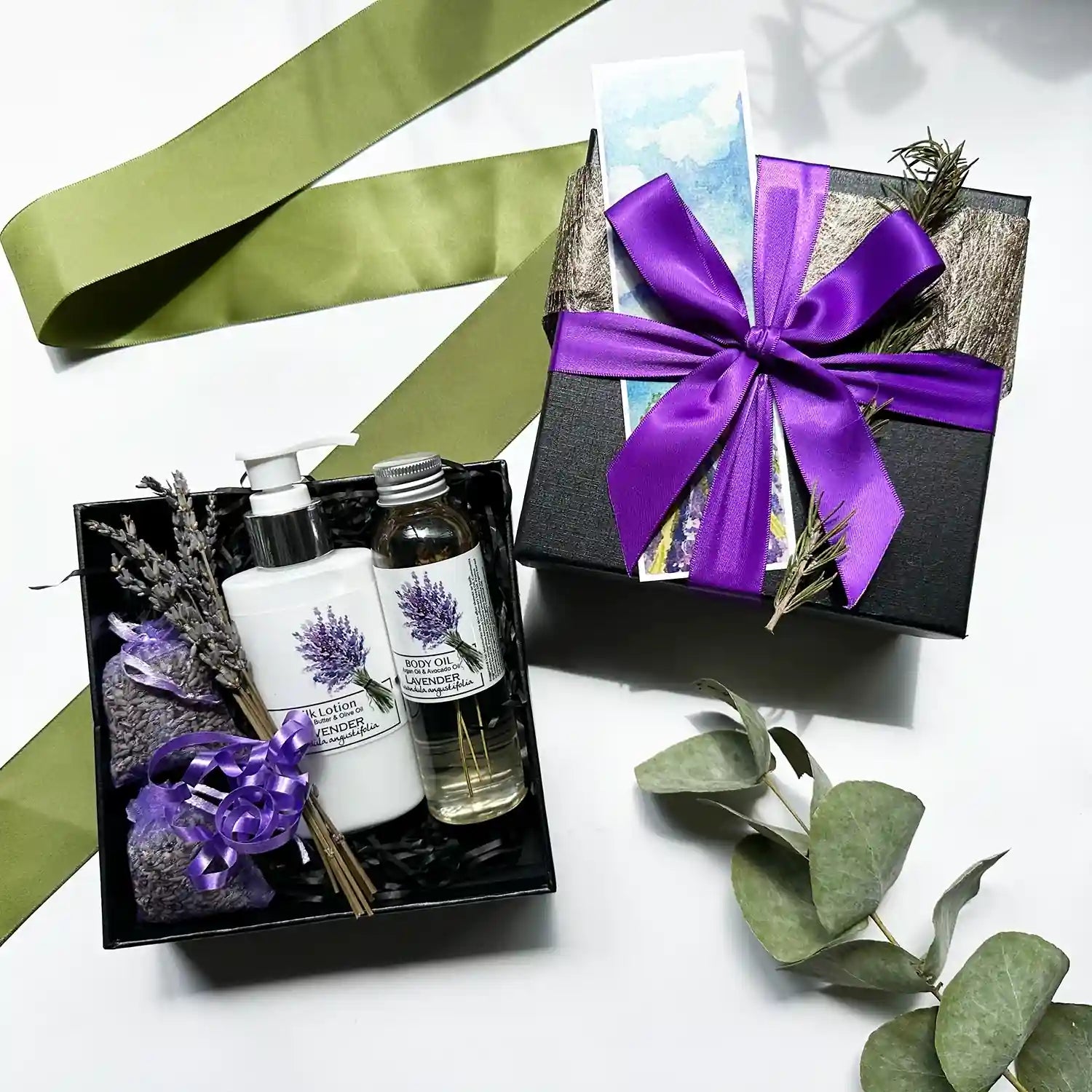 Gift box containing Lavandula Angustifolia lavender essential oil scented lotion and body oil, with lavender sachets, wrapped with a purple ribbon black gift box and lavender field bookmark for a soothing and aromatic experience.