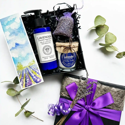 Lavender Aroma Gift Box featuring a French lavender body lotion, a lavender soy candle scented with essential oils, a lavender sachet wrapped in purple ribbon, and a lavender field bookmark.