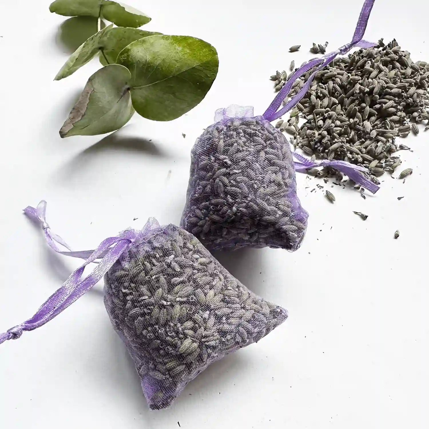 Lavender bags for drawers or closets with a background of loose lavender dried flower rubbings and eucalyptus leaves.