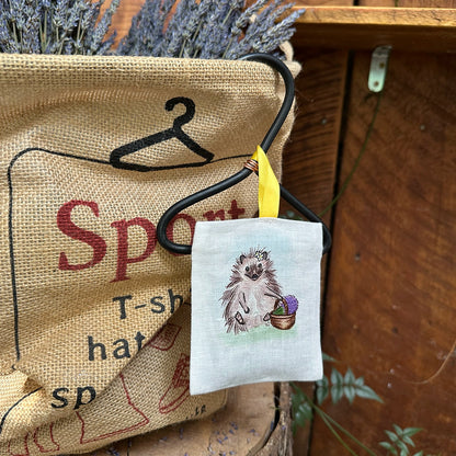 Lavender drawer sachet with a scented hedgehog design, hanging in a basket filled with fresh lavender flowers.