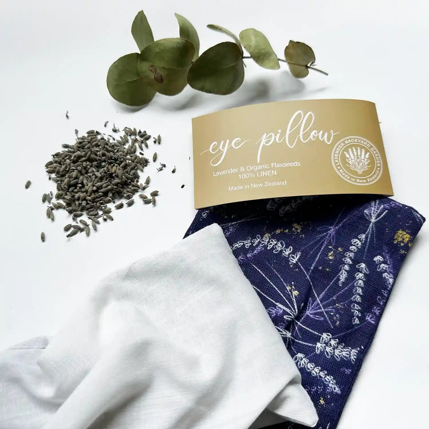 Lavender eye pillow showcasing the inner linen pack with a removable cover, beautifully decorated with eucalyptus leaves and lavender rubbings in the background.