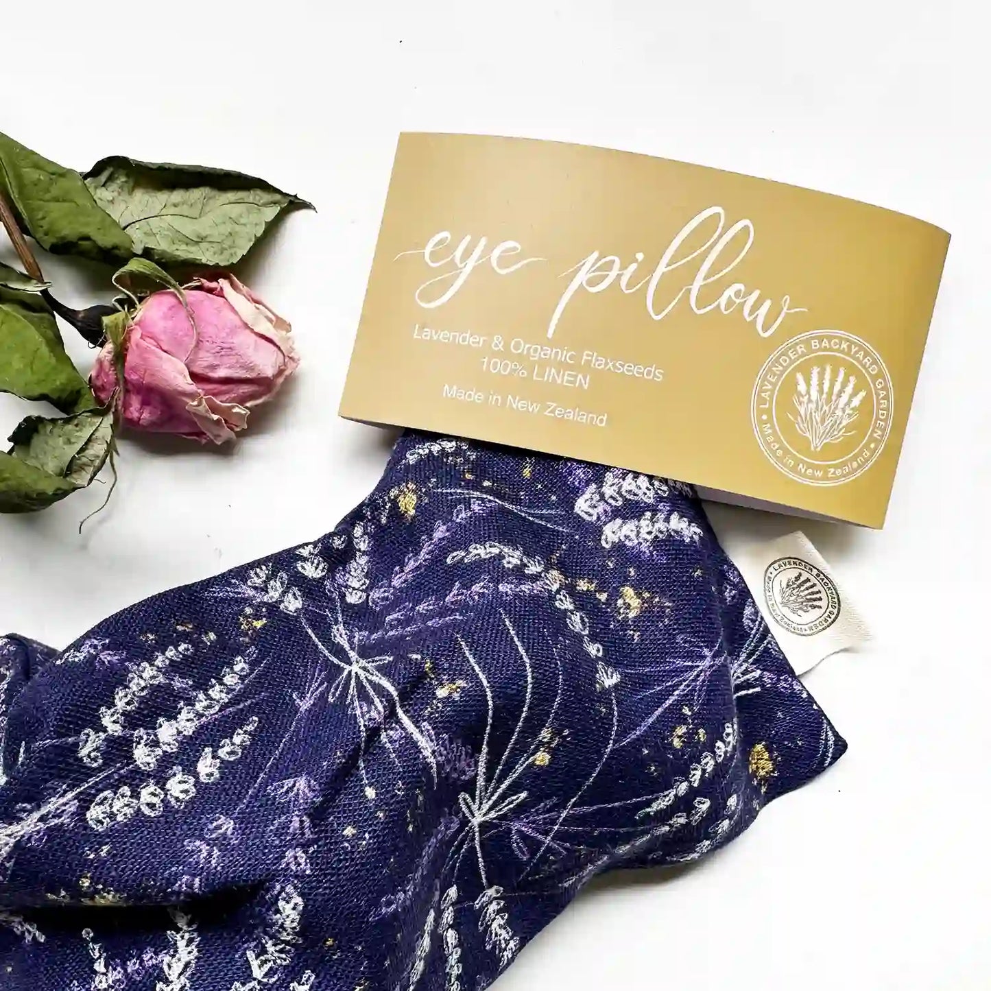 Close-up view of a lavender flaxseed weighted eye pillow, showcasing the fabric texture and adorned with dried rose petals for an elegant touch.