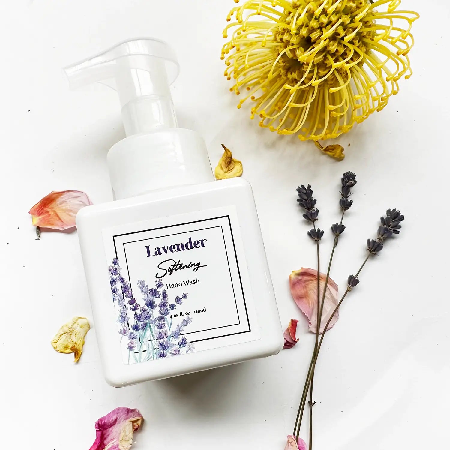 Lavender Foaming Hand Soap for hand hygiene, with background decoration of fresh flowers, rose petals, and dried lavender flowers.