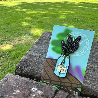 A jar of lavender fridge magnets on a farm table with a green lawn in the background