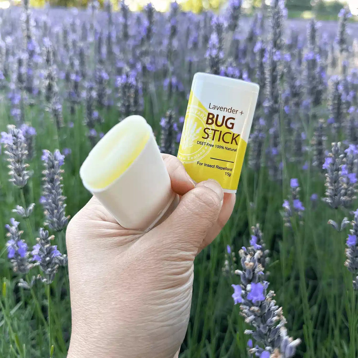 Holding by hand with the lid open, showcasing the inner texture of the Lavender Insect Repellent Balm scented by essential oils.