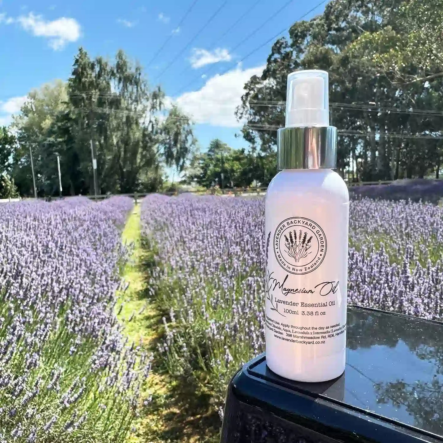 Lavender Magnesium Oil Spray displayed with a serene lavender field background at Lavender Backyard Garden, NZ.