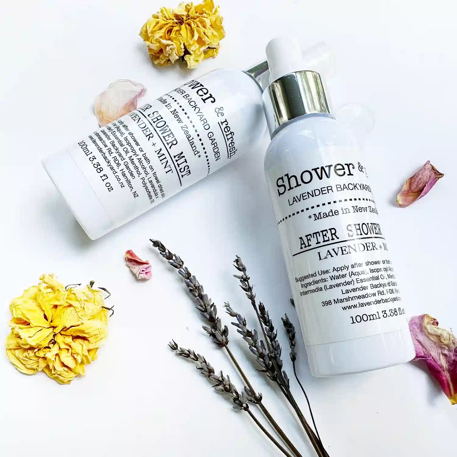 Two bottles of Lavender & Mint Daily Moisturising After-Shower Mist - Cooling Spray with yellow rose and dried lavender flowers in the background, highlighting natural ingredients.