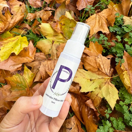 Travel Size Lavender Pillow Mist spray bottle with autumn leaves in the background.