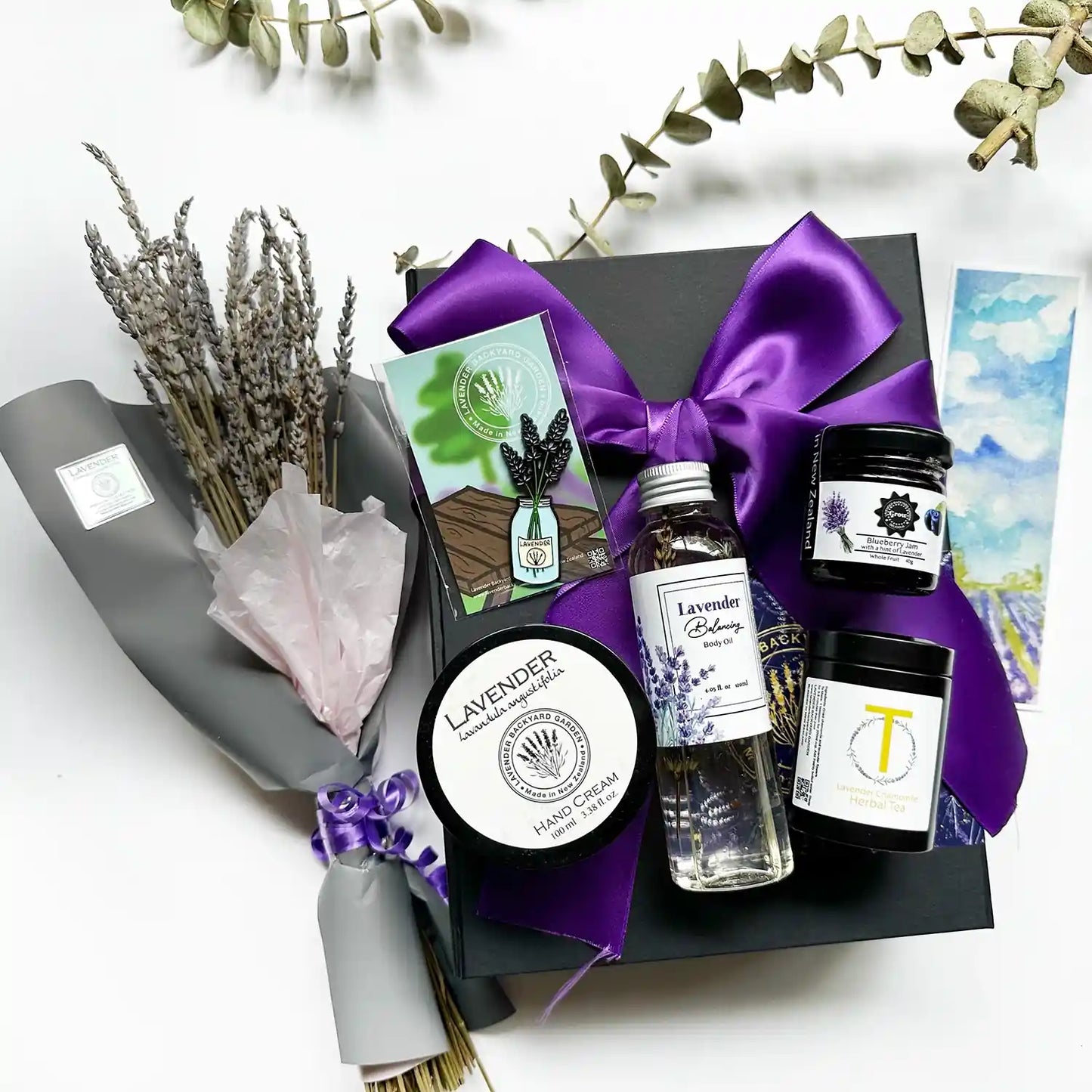 Romantic Gift Box for Valentine's Day - Lavender Dried Flower Bouquet, Lavender Hand Cream, French Lavender Body Oil, Lavender & Camomile Herbal Tea (Travel Mini), Blueberry Jam with a Hint of Lavender (40g), Lavender Fridge Magnets in a Jar, Lavender Field Bookmark, elegantly wrapped in a purple ribbon black gift box.