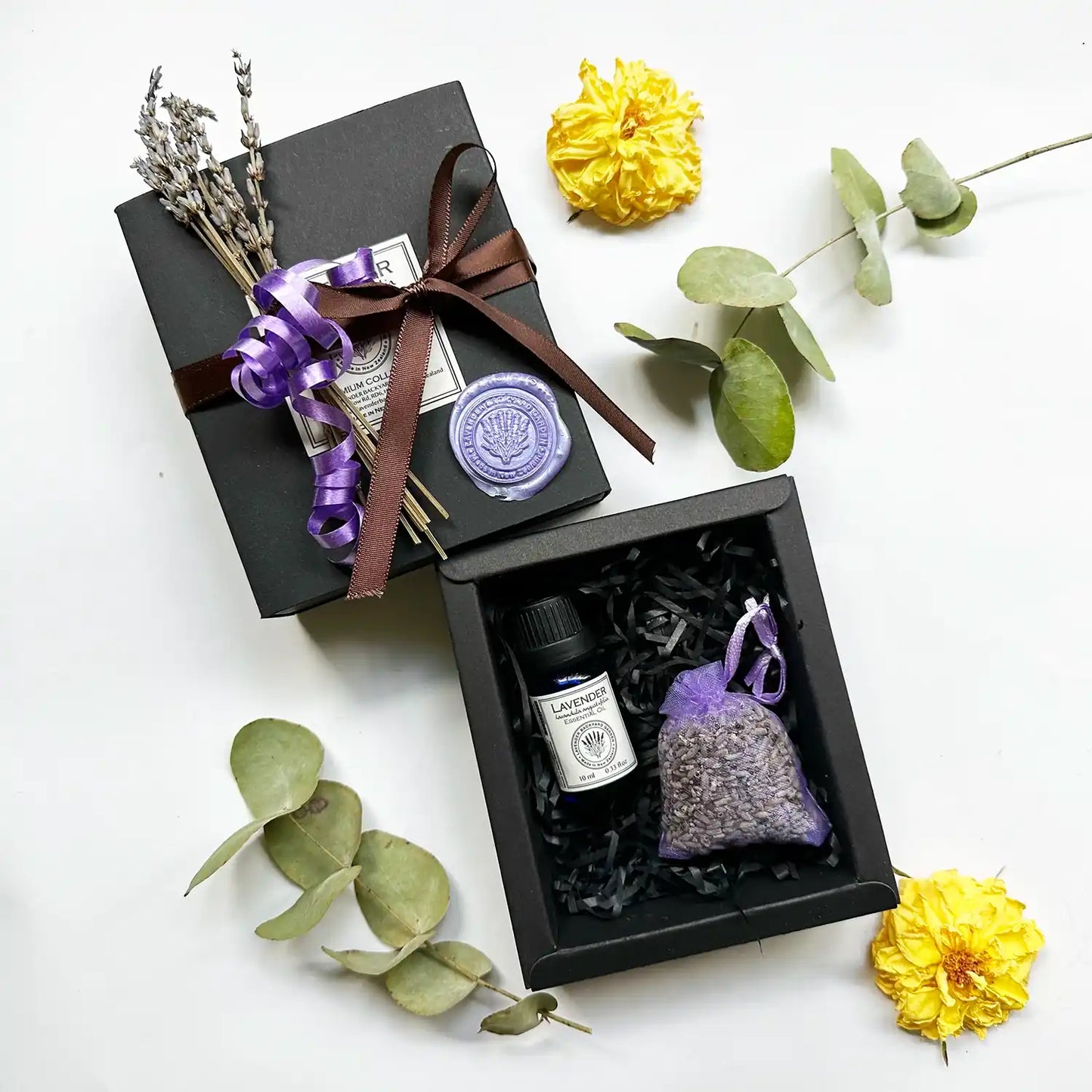 Loving Memory Support Gift Set featuring a dried lavender sachet, aromatherapy pure lavender essential oils, and a mini dried lavender flower, all wrapped in a brown ribbon.