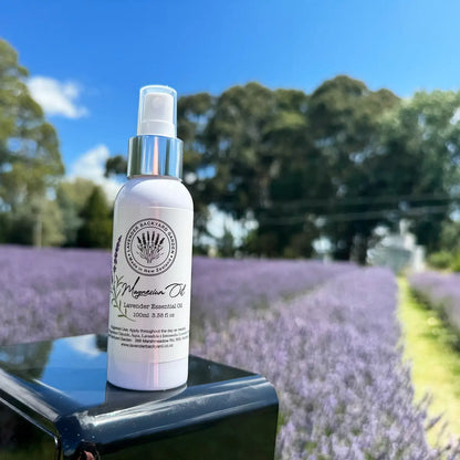 Magnesium Oil with Lavender placed on a black box against the background of lavender rows at Lavender Backyard Garden, NZ.