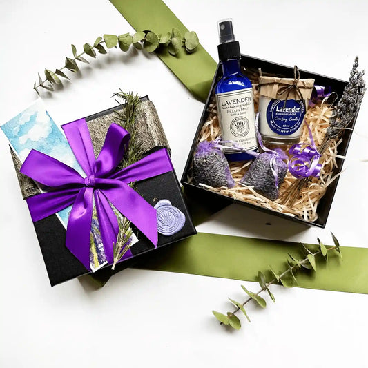 Merry Christmas! Lavender Relaxation Gifts for a Woman" gift box featuring a lavender sleep spray, soy candle scented with lavender essential oil, lavender drawer sachet, all elegantly wrapped with a purple ribbon gift box and a lavender field bookmark.