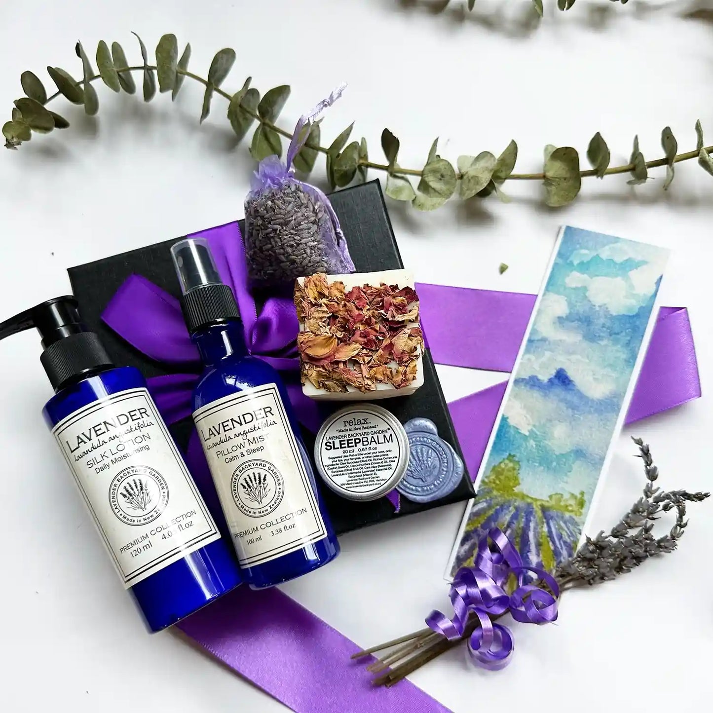 Merry Xmas! Christmas Holiday Cheer Gift Basket featuring lavender essential oil scented handmade soap, pillow mist, body lotion, and a lavender sachet, elegantly wrapped with a purple ribbon.