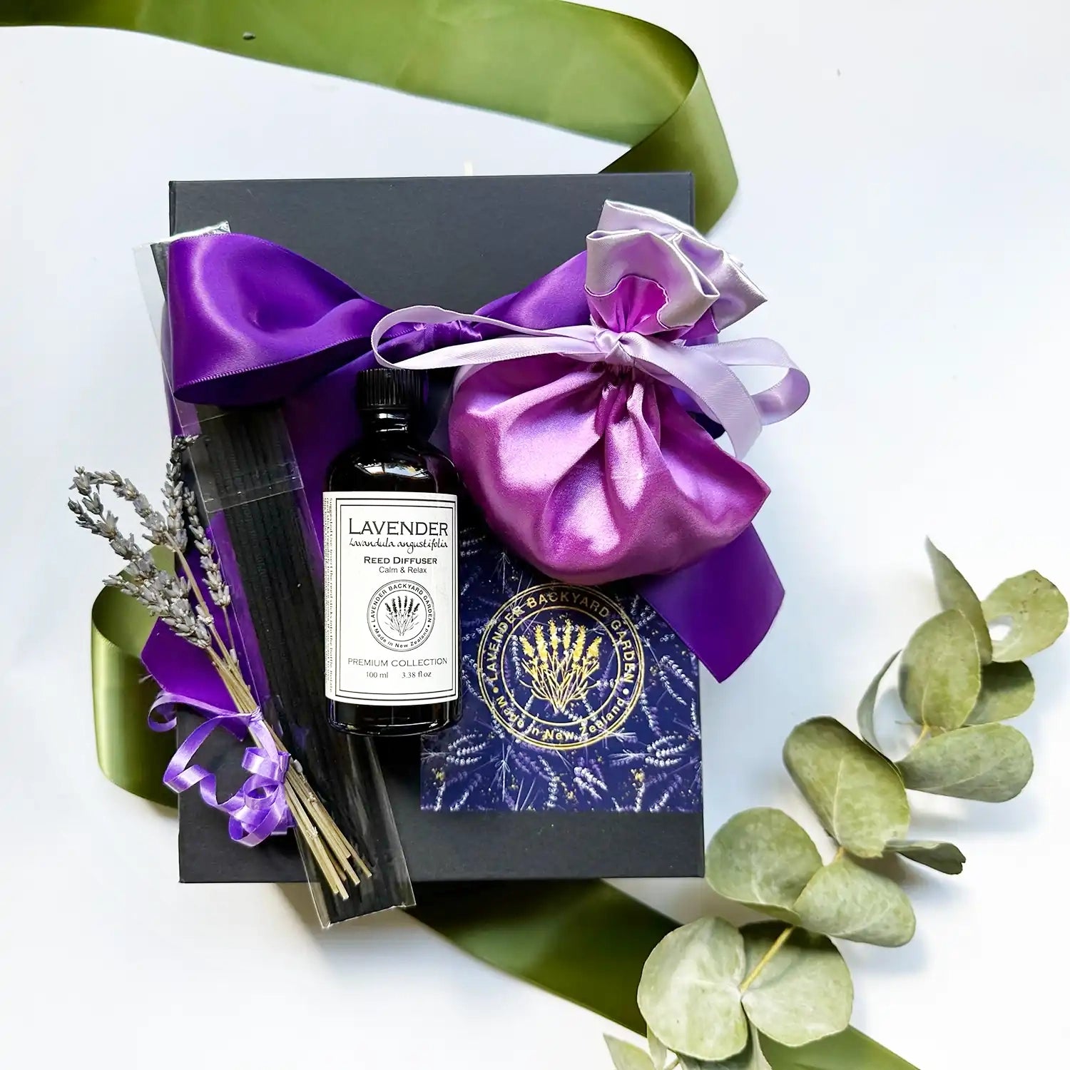 Mom's Day Heartfelt Surprises gift box featuring a Reed Diffuser scented by lavender essential oil, a luxury satin lavender bag, wrapped with a purple ribbon black gift box adorned with mini dried lavender flowers.