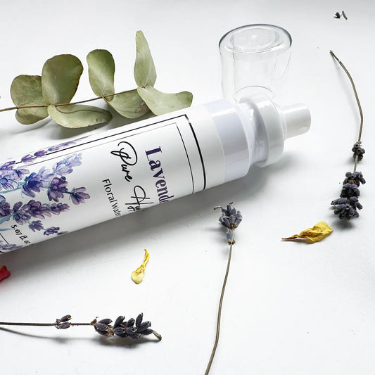 Close-up of natural face toner with lavender flower water, set against a background decorated with dried English lavender, eucalyptus leaves, and rose petals.