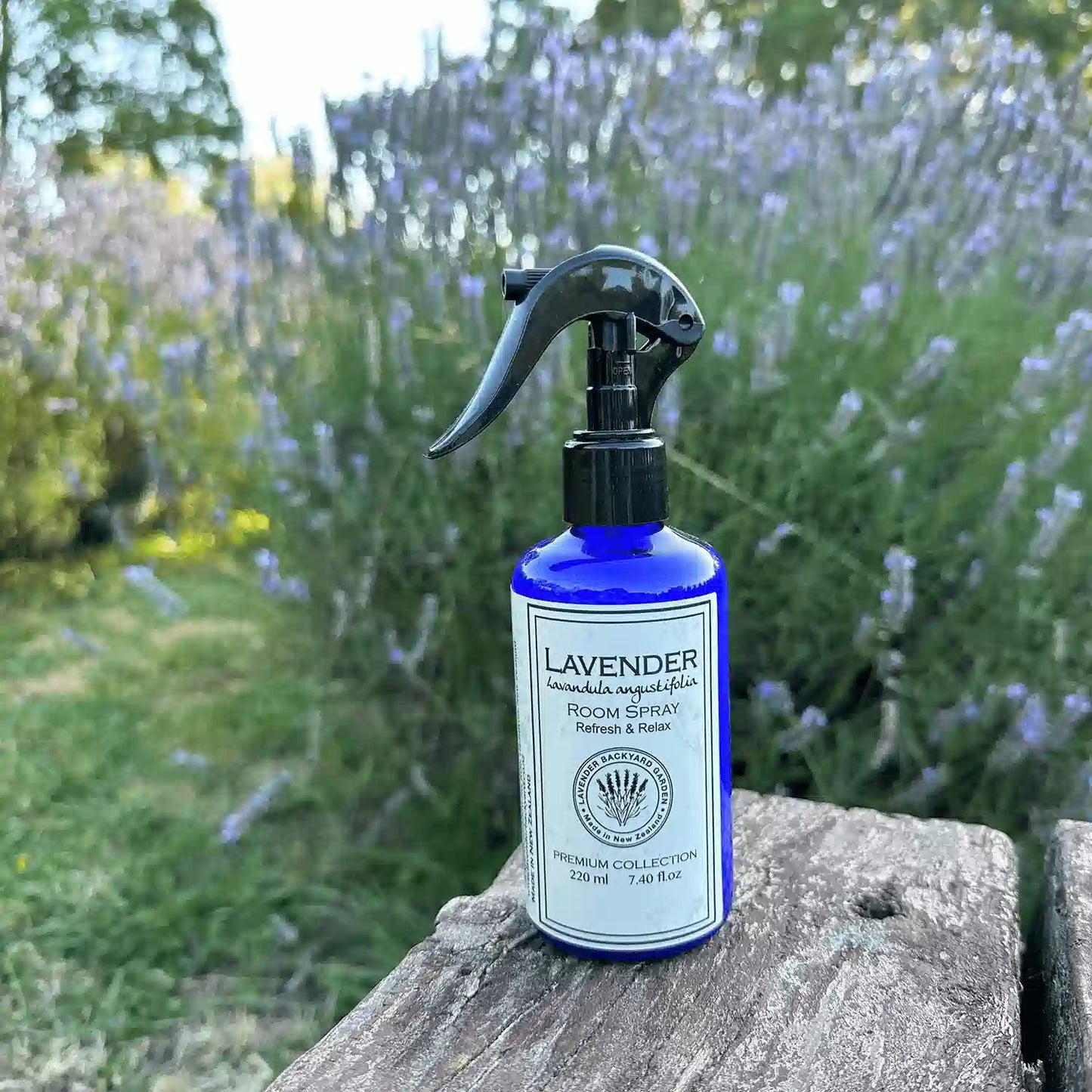 Lavender Air Freshener for Home placed on a wooden bench, with a background of lavender blooming at Lavender Backyard Garden, NZ.