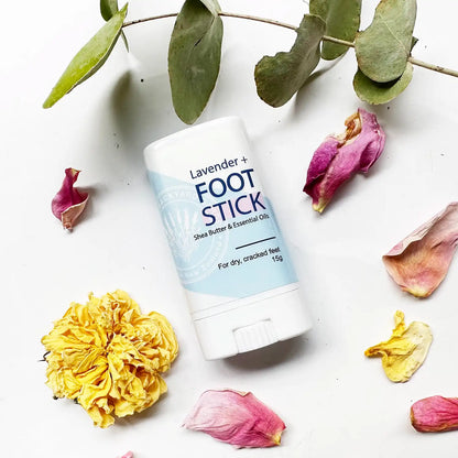 Nourishing foot balm for cracked feet scented with lavender essential oil, with eucalyptus leaves and dried roses in the background.