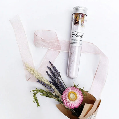 Relaxing Floral Bath Salts Tube with the background of dried lavender bouquets and pink ribbon as decoration.