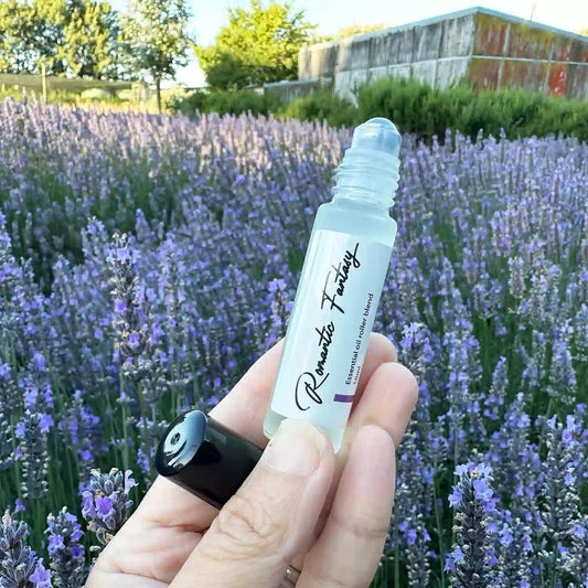 Romantic Fantasy Essential Oil Natural Perfume, displayed with the Lavender Backyard Garden farm shed and purple blooming lavender field in the background.