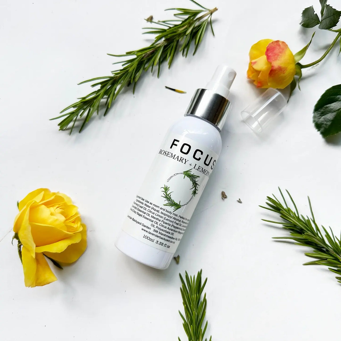 Focus Aromatherapy Spray with Pure Essential Oils set against a background of rose flowers and fresh rosemary leaves.