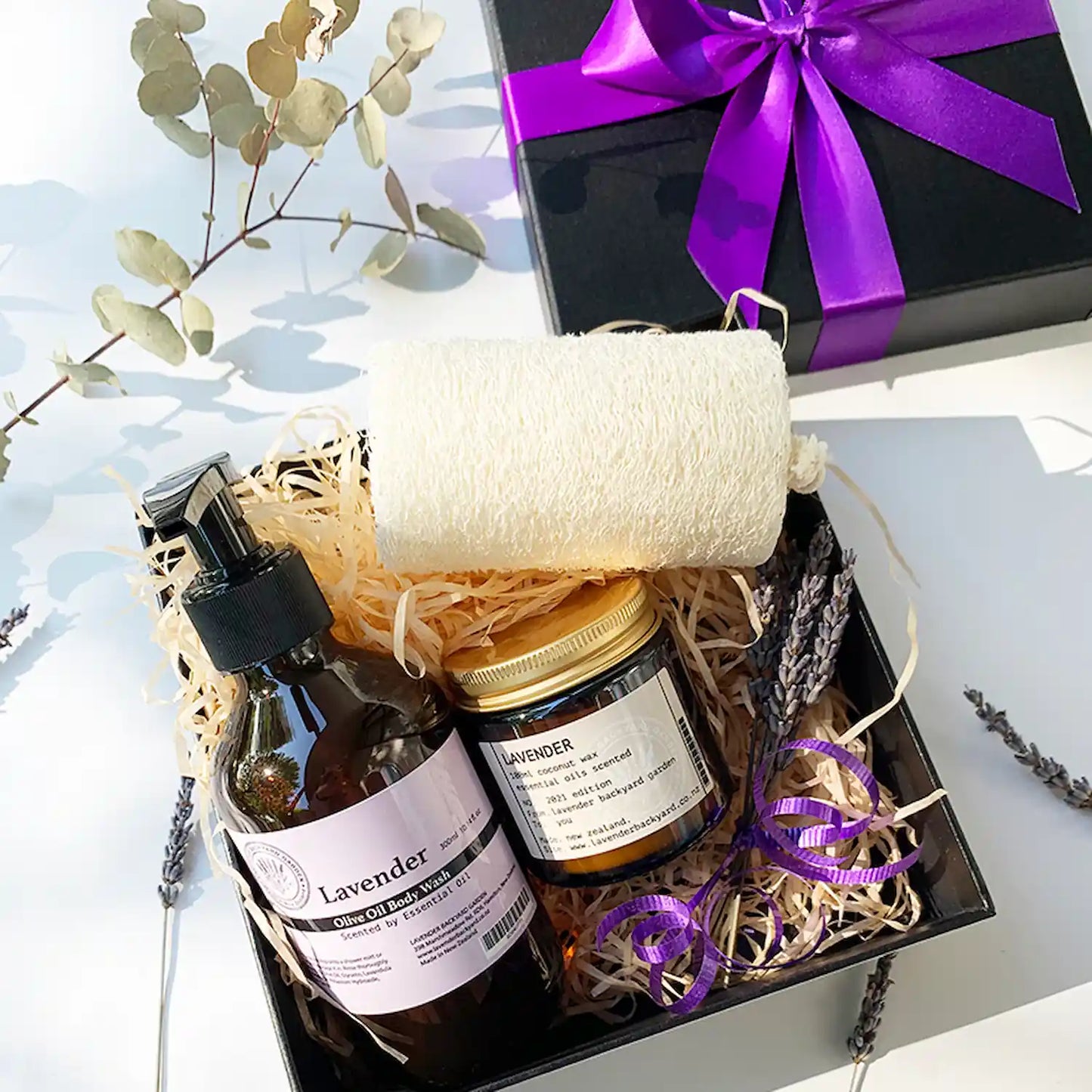 Showertime Indulge Gift Box featuring Lavender Body Wash Shower Gel, Lavender Coconut Wax Candle, Egyptian Natural Loofah, Mini Lavender Dry Flower, and Lavender Field Bookmark, perfect for a relaxing shower experience.