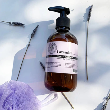 Therapy lavender body wash shower gel with light reflecting on the bottle, decorated with dried lavender flowers in the background.