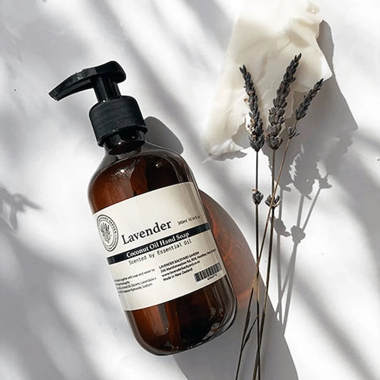 Therapy Lavender Hand Wash with a soothing lavender aroma, featuring a background of coconut oil and dried lavender flowers.