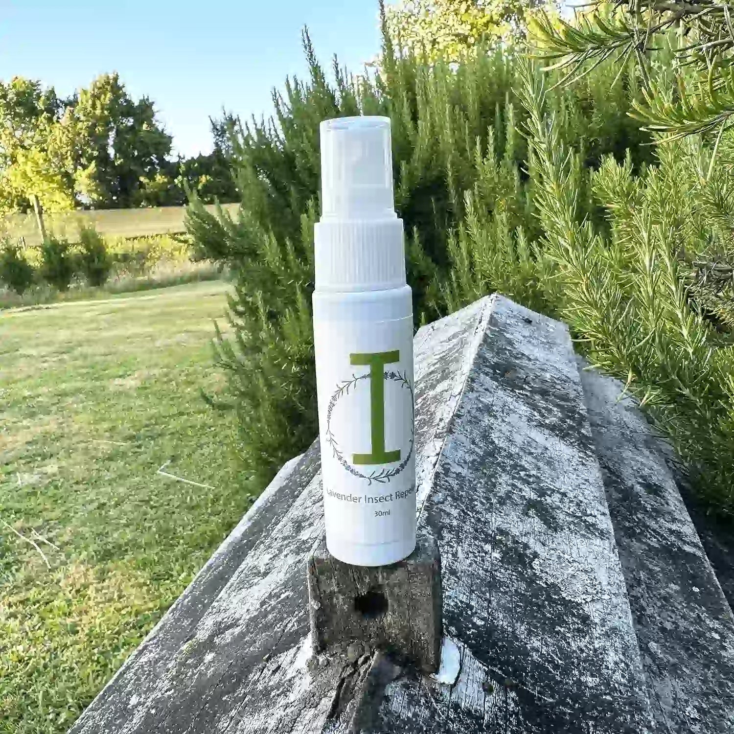 Lavender insect repellent spray placed on an old beehive with the background of rosemary bushes at Lavender Backyard Garden, NZ.