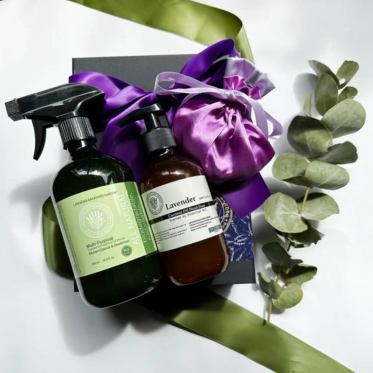 Image of an Upscale Kitchen Essentials Gift Set containing lavender enzyme all-purpose cleaning spray and hand wash, both scented by lavender essential oil, wrapped with a purple ribbon in a black gift box.